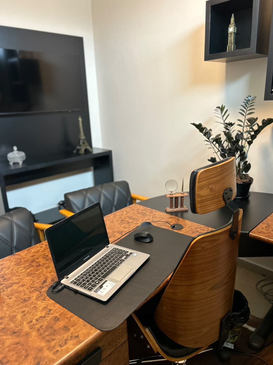 Espaço de trabalho com mesa, notebook e cadeiras de couro