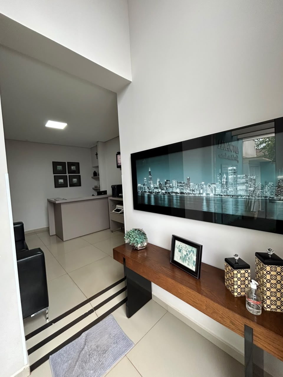 Recepção do escritório com painel da cidade e aparador